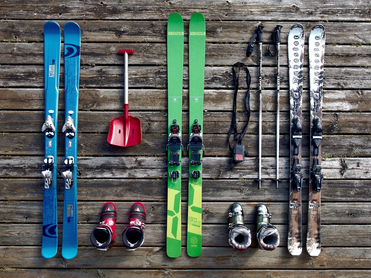 about-02 Collection of ski gear on a wooden deck, showcasing vibrant colors and vintage style.